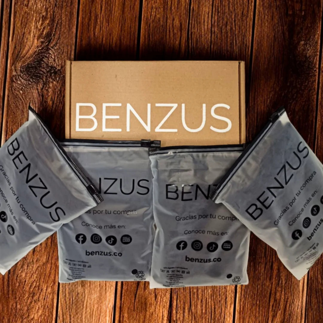 Contenido del Quad-Pack Pro de BENZUS. Vista superior de una caja de envío abierta y cuatro empaques individuales herméticos con acabado esmerilado y logo negro. Muestra la presentación completa y segura del paquete de 4 boxers para hombre.